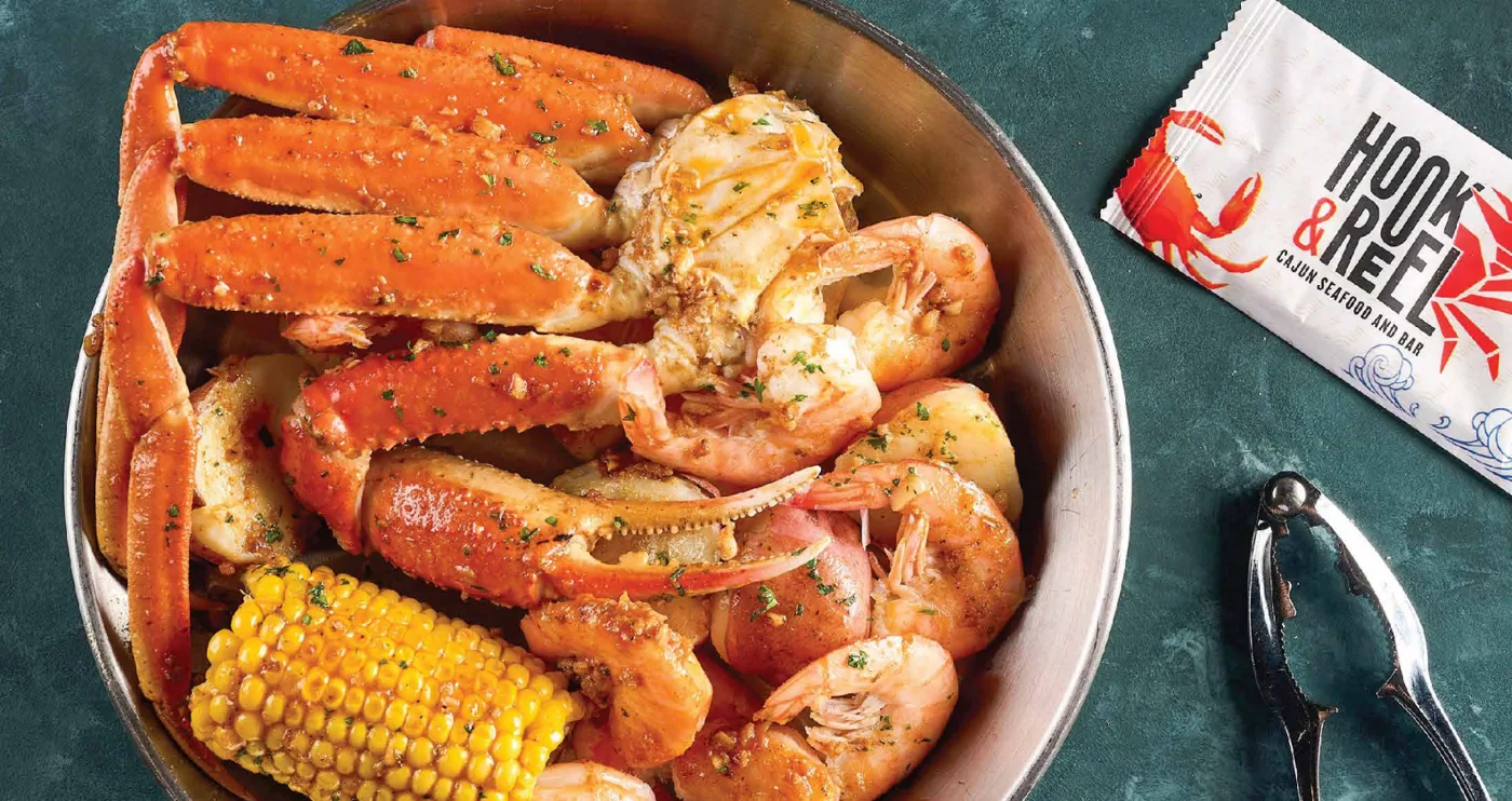 A bowl of snow crab legs, shrimp and corn on the cob from a seafood boil