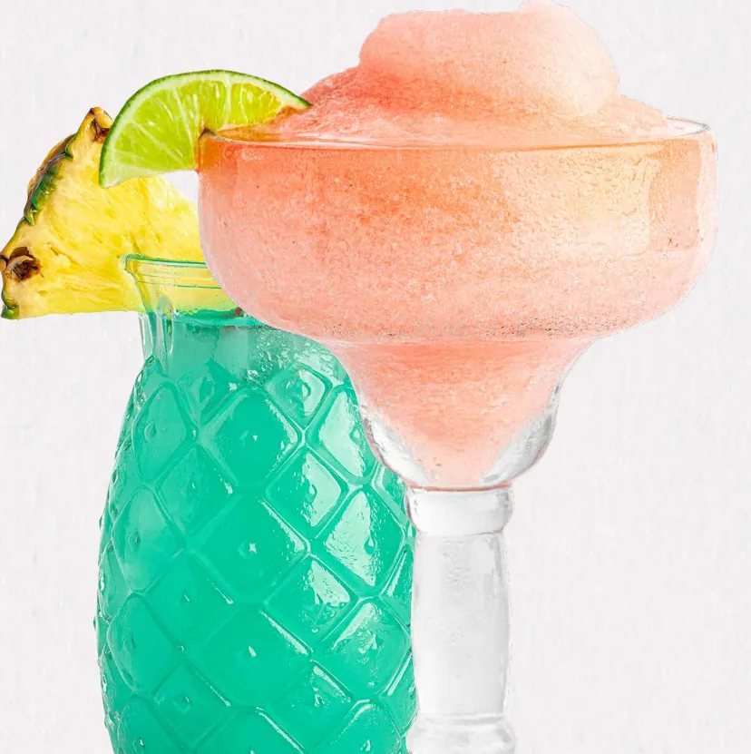 A pink frozen margarita beside a blue pineapple-shaped cocktail glass